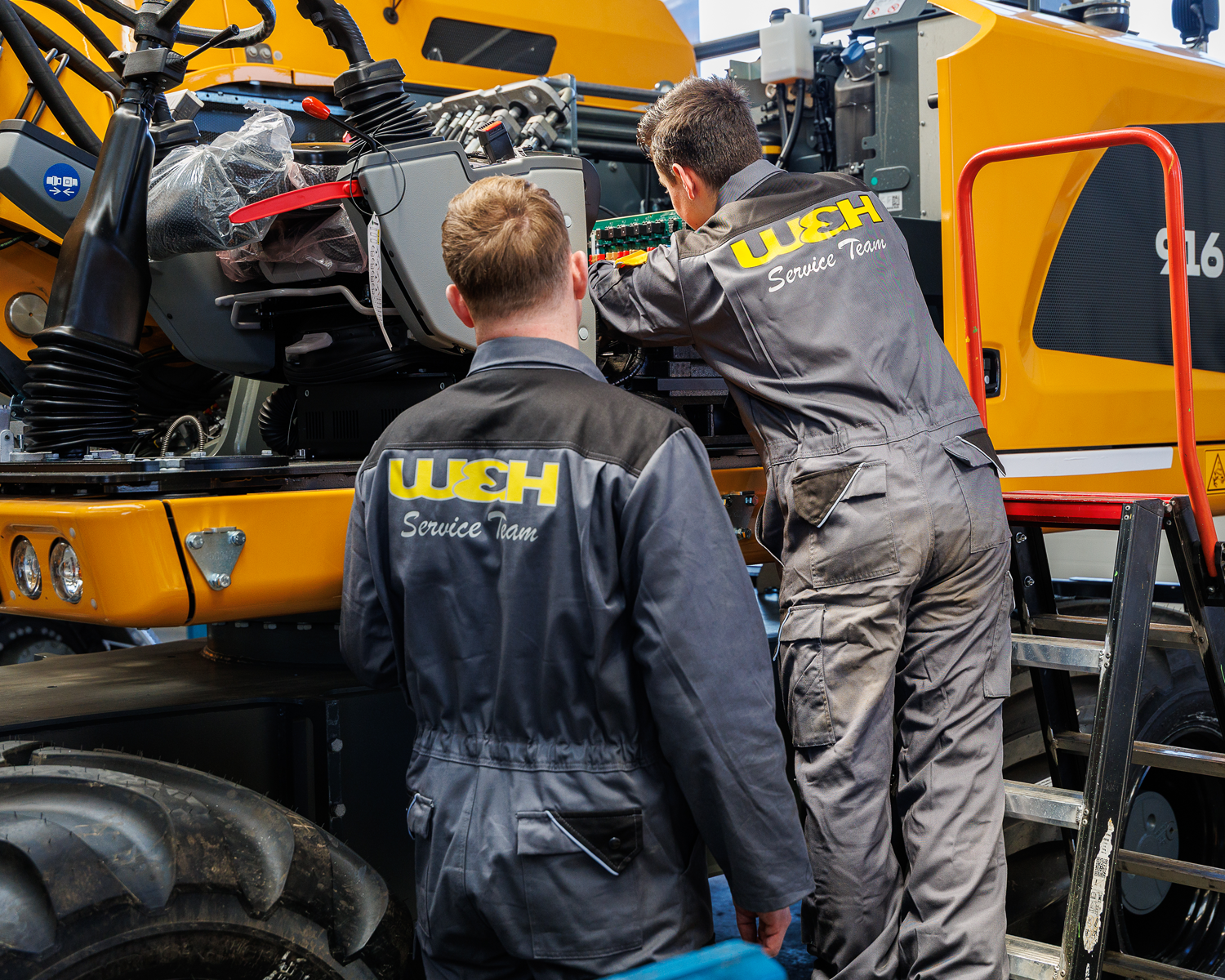 2 monteurs bij grondverzetmachine