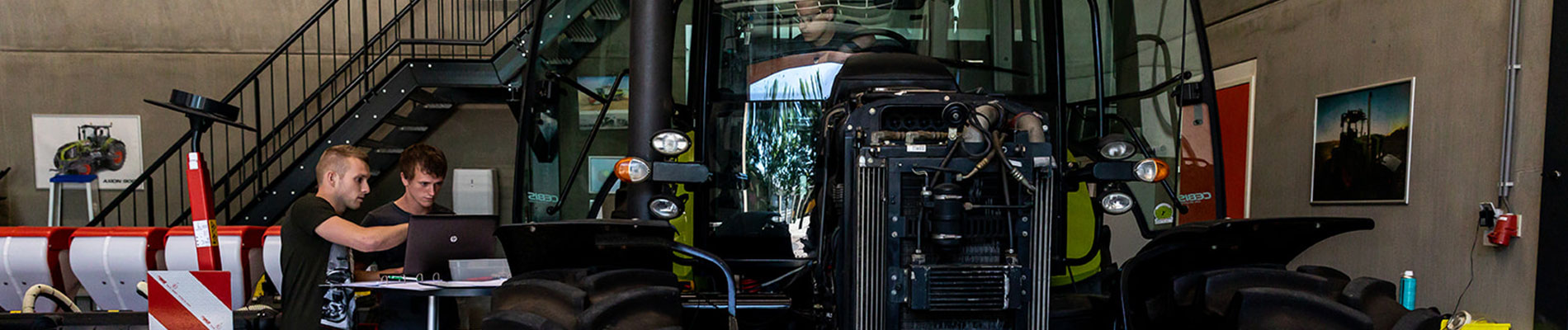 3 leerlingen werken aan een Claas tractor