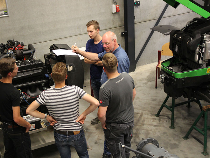 Docent in gesprek met leerlingen over tractor