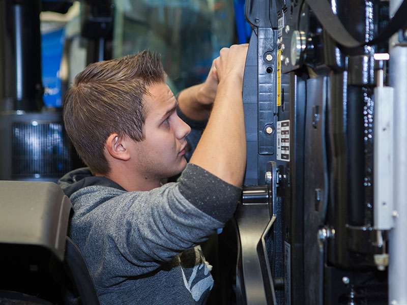 Leerling werkt aan New Holland tractor