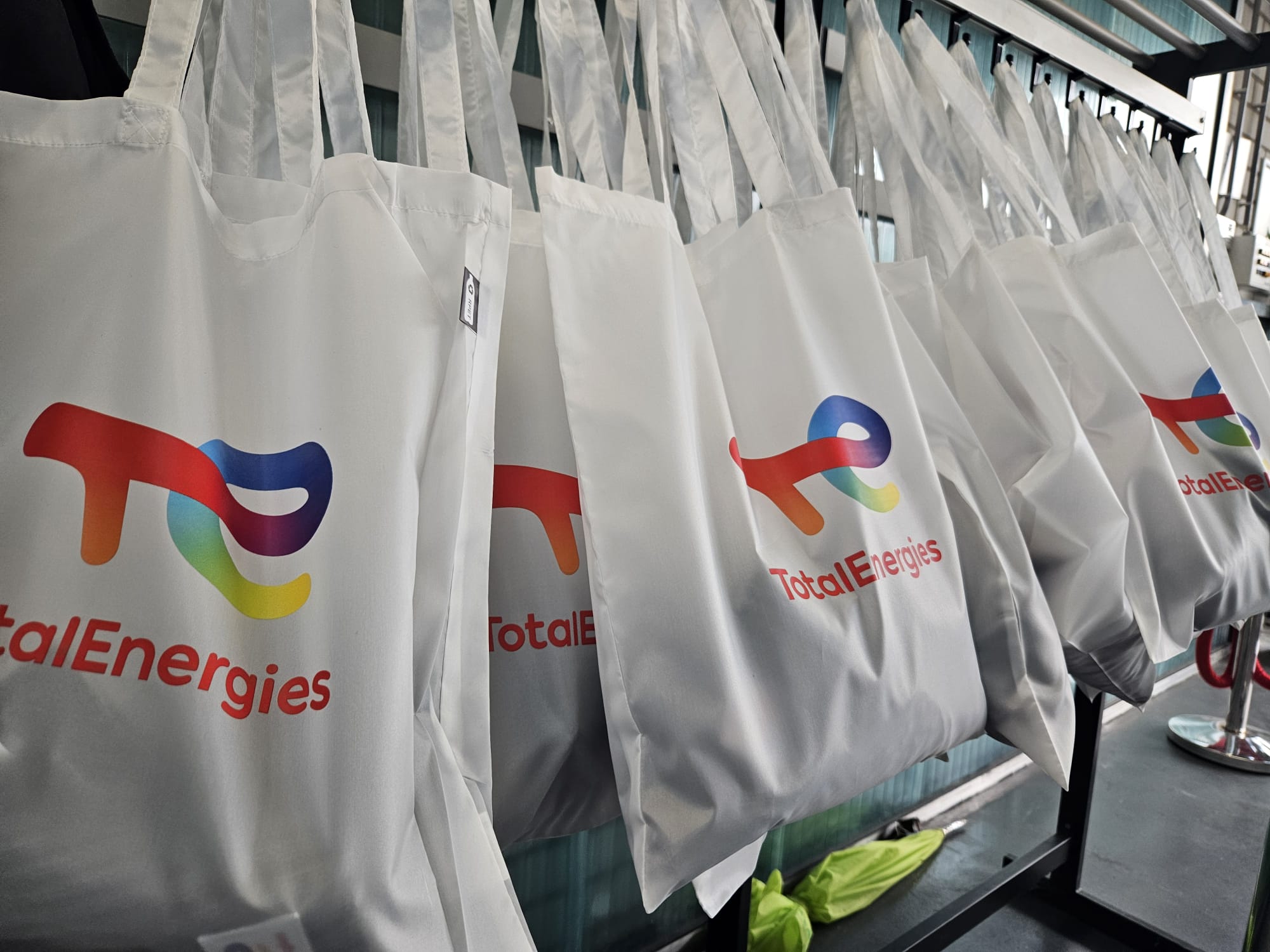 Witte goodiebags met het kleurrijke logo van TotalEnergies hangen op een rij, klaar om uitgedeeld te worden tijdens de gastcolleges bij Aeres Tech.